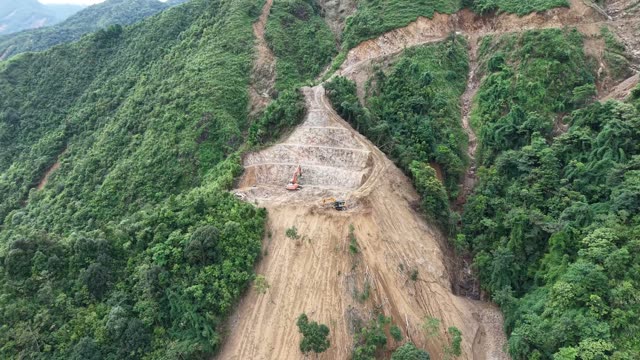 Excavator Carving Ridge Amid Forest