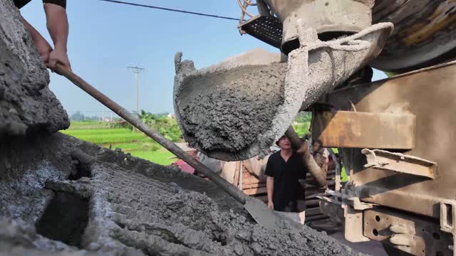 Worker Shoveling Wet Concrete