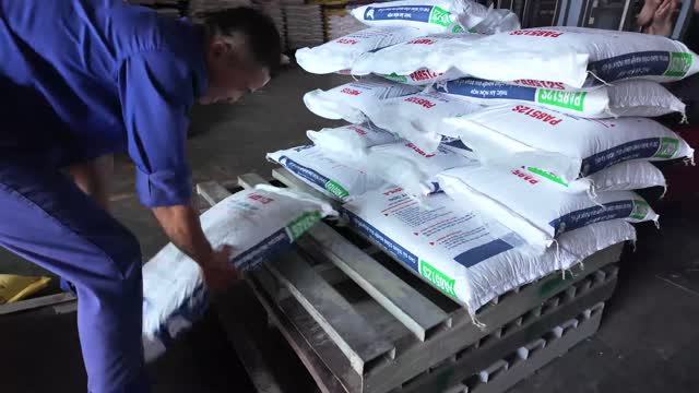 Worker Stacking Feed Sacks