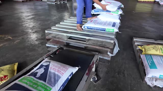 Worker Weighing Animal Feed Sacks