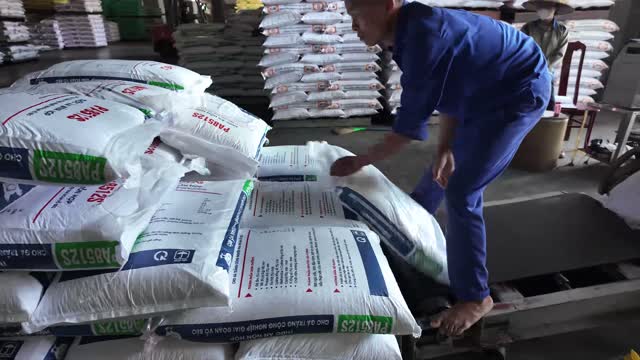 Worker Handling Feed Sacks