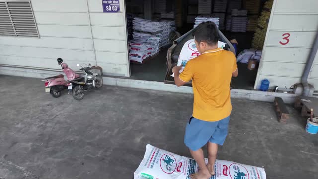 Man Hauling Sack Into Warehouse
