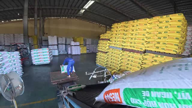 Worker Among Feed Sack Stacks