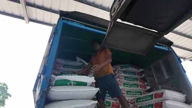 Worker Stacking Feed In Truck