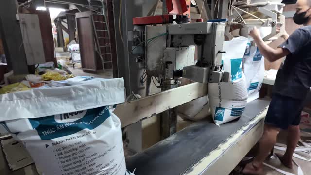 Worker Filling Feed Sacks