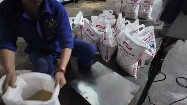 Worker Filling Animal Feed Bags