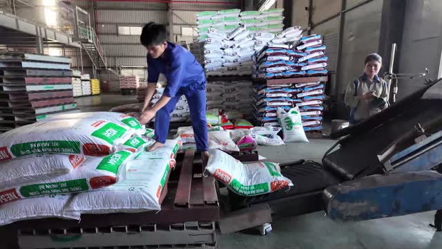 Worker Stacking Feed Bags