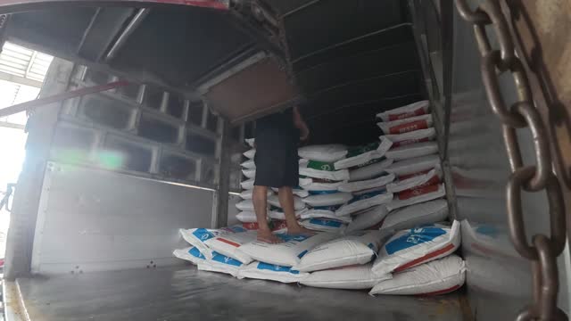 Worker Loading Truck With Feed