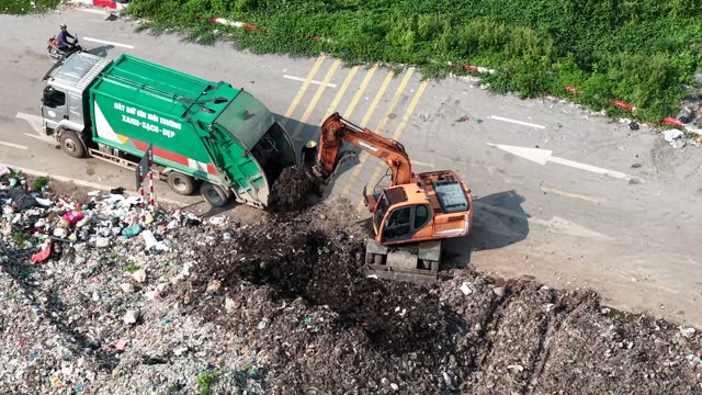 Excavator Spreading Trash Pile