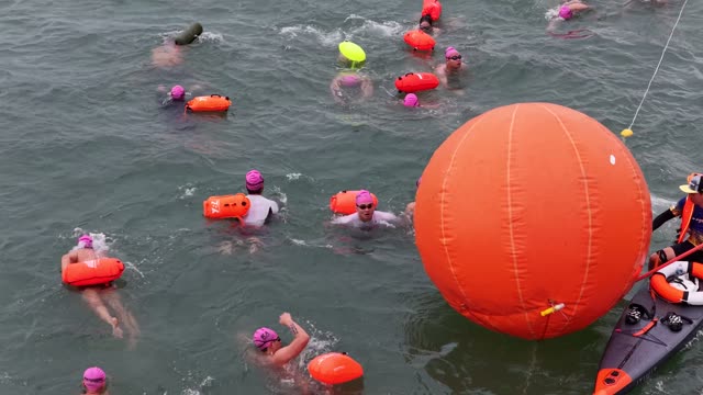 Swimmers Round Orange Buoy