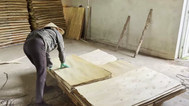 Worker Flattening Veneer Stack