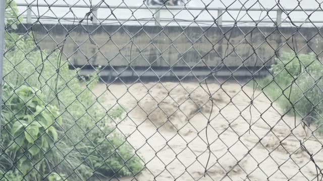 Raging Flood Behind Fence