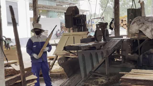 Worker At Vertical Bandsaw