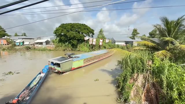 Boat Passing Riverside Village